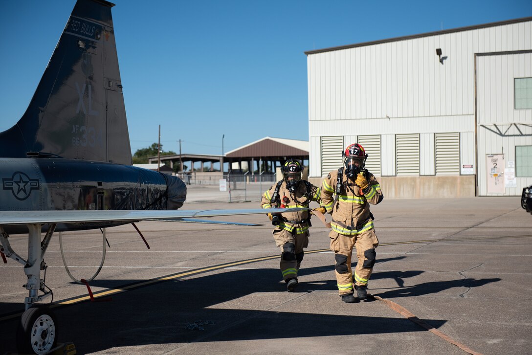 Armando Delgado, 47th Civil Engineer Squadron fire department firefighter and Kenneth Gonzales, 47th CES firefighter, move around the aircraft to extinguish the mock fires so they can safely retrieve the pilot, Sept. 30, 2020, at Laughlin Air Force Base, Texas. The drills were to measure the skills of the firefighters and be better prepared in emergencies. (U.S. Air Force photo by Airman 1st Class David Phaff)