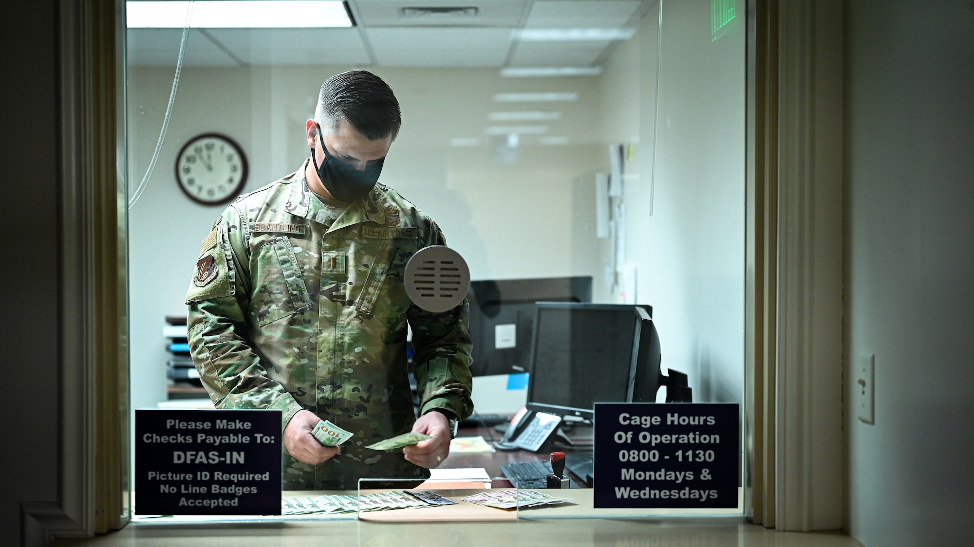 2nd Lt. Shane Scantling, 75th Comptroller Squadron financial systems officer, counts money inside the disbursement cage.