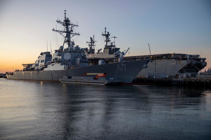 The Arleigh-Burke class guided missile destroyer USS Cole (DDG 67) and the Wasp-class amphibious assault ship USS Iwo Jima (LHD 7) sit pier-side at Naval Station Norfolk, Virginia during sunset, Oct. 8, 2020.