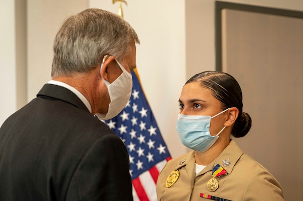 Acting Under Secretary of the Navy Gregory J. Slavonic awards Master-at-Arms 2nd Class Yaisa Coburn with the Navy and Marine Corps Medal during an award ceremony at Naval Air Station Corpus Christi.