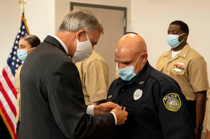 Acting Under Secretary of the Navy Gregory J. Slavonic awards officer Stuart Levitt with the Distinguished Civilian Medal for Valor during an award ceremony at Naval Air Station Corpus Christi.