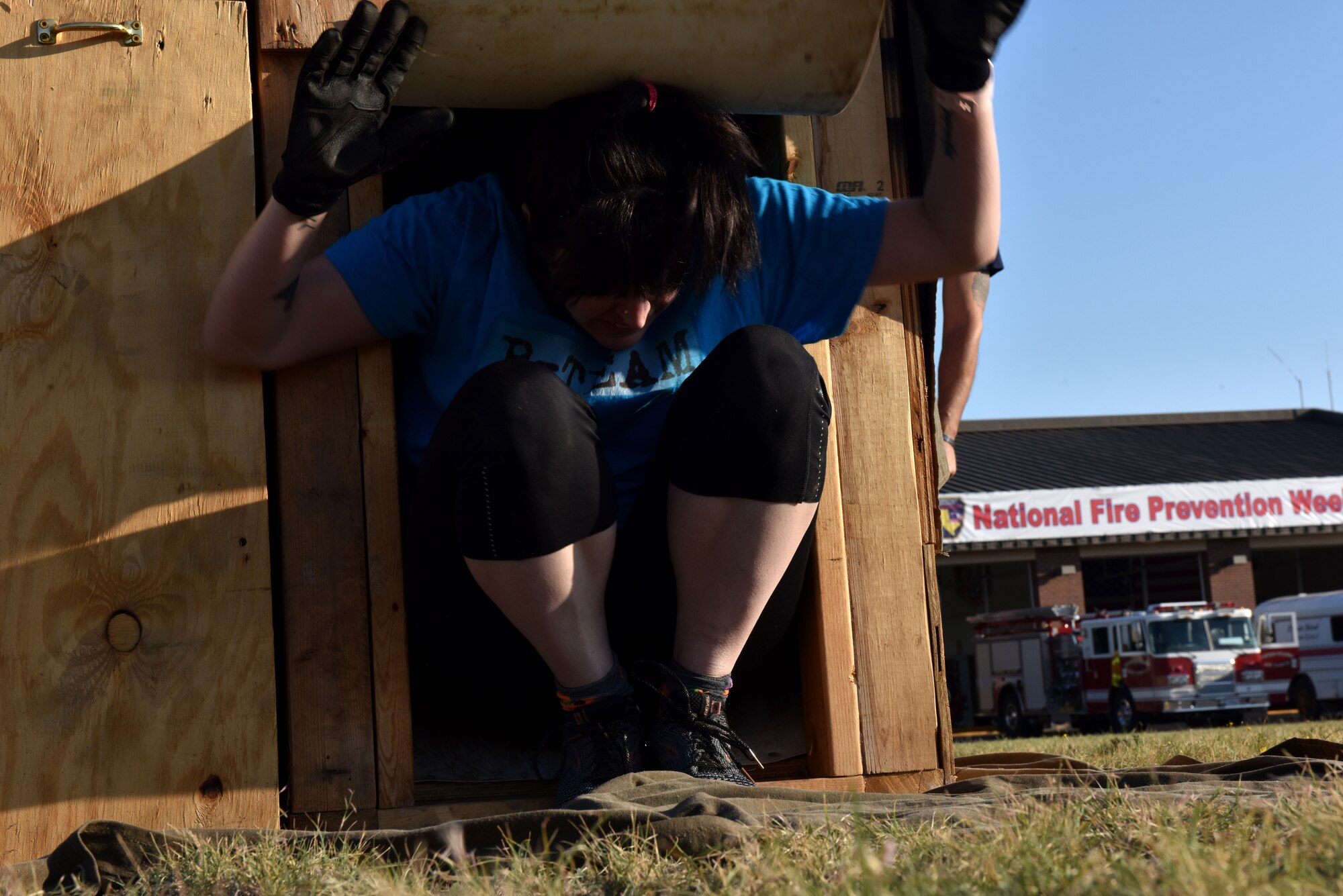 A Fire Muster Challenge participant exits the wooden confined space trainer during the obstacle course at the Goodfellow Fire Department on Goodfellow Air Force Base, Texas, Oct. 9, 2020. Confined space trainers are used to test firefighter’s ability to remain in control in a small space. (U.S. Air Force photo by Staff Sgt. Seraiah Wolf)