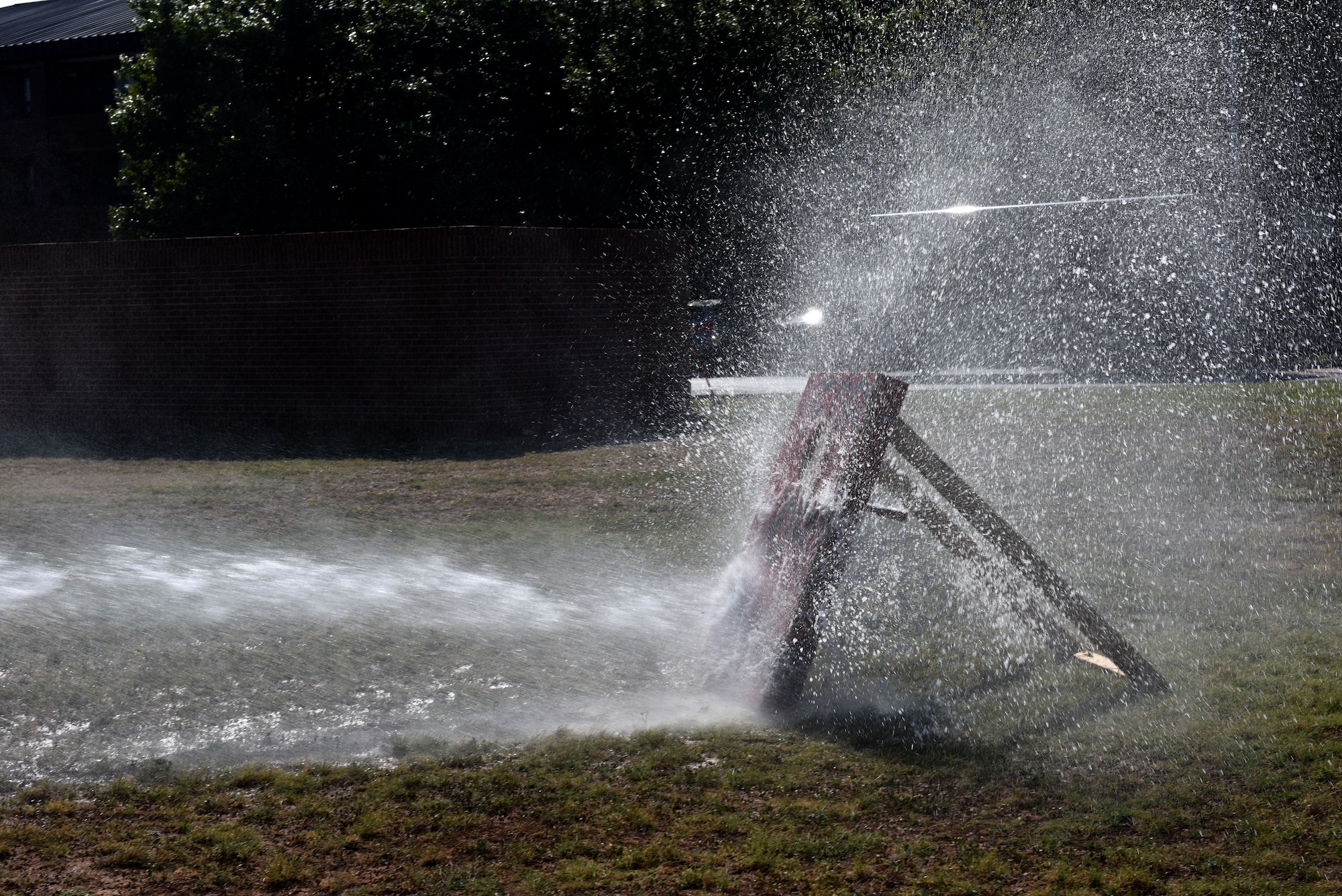 A target is sprayed from a charged fire hose during the 15th Annual Fire Muster Challenge at the Goodfellow Fire Department on Goodfellow Air Force Base, Texas, Oct. 9, 2020. The whole team held the hose in place while spraying the target. (U.S. Air Force photo by Staff Sgt. Seraiah Wolf)
