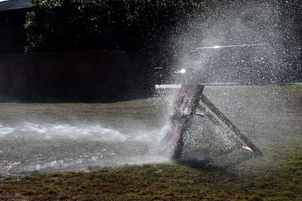 A target is sprayed from a charged fire hose during the 15th Annual Fire Muster Challenge at the Goodfellow Fire Department on Goodfellow Air Force Base, Texas, Oct. 9, 2020. The whole team held the hose in place while spraying the target. (U.S. Air Force photo by Staff Sgt. Seraiah Wolf)