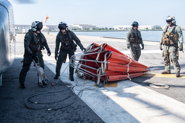 Sailors assigned to Helicopter Mine Countermeasures Squadron (HM) 12, and HM-14, prepare an HL-5000 Bambi Bucket for aerial firefighting training exercises, Sept. 3, 2020.