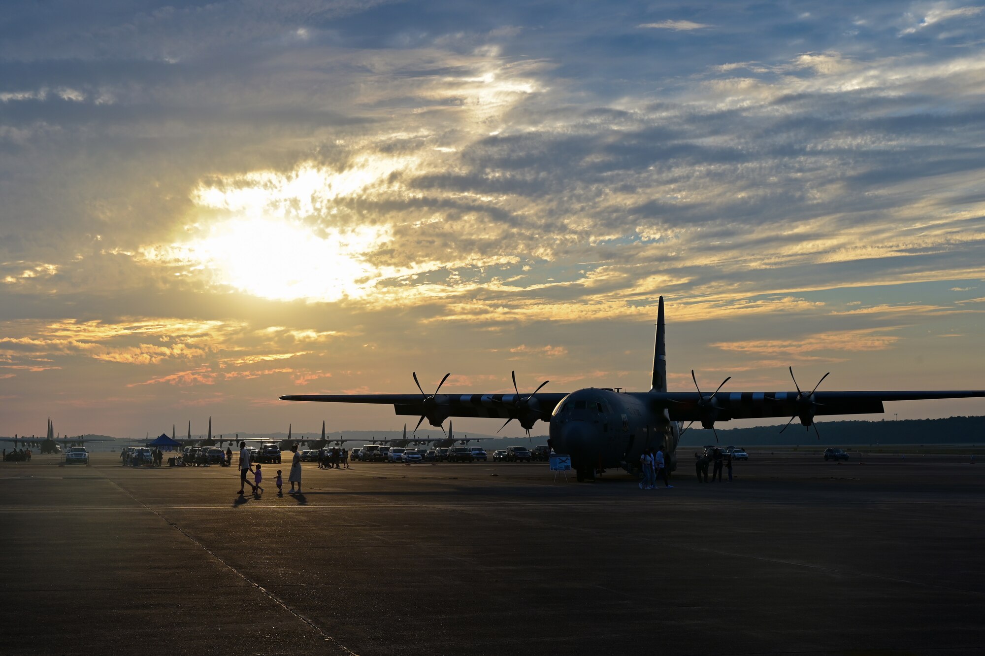 A Family walks in front of an aircraft at sunset