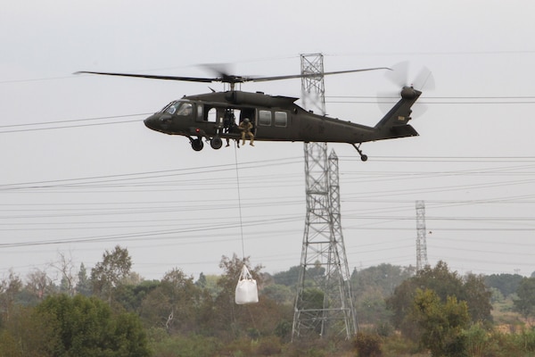 A California Army National Guard UH-60 Black Hawk places a 3,000-pound sandbag at the Whittier Narrows Dam Basin in Montebello, California, as part of an exercise during which the district teamed up with the California Army National Guard to demonstrate flood-mitigation capabilities.