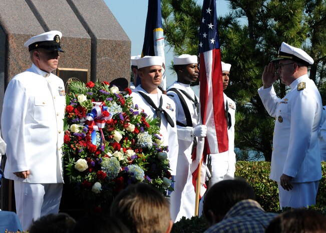 Adm. J. C. Harvey Jr., right, commander of U.S. Fleet Forces Command, salutes as Master Chief Steven Timmons, left, and Seaman Dingji Zhuang, both assigned to the guided-missile destroyer USS Cole, present a wreath at the USS Cole memorial at Naval Station Norfolk during the 10th anniversary remembrance ceremony of the terrorist attack on Cole.