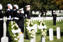 A bugler plays Taps in Arlington National Cemetery, Arlington, Va., Oct. 12, 2015, during a ceremony to remember the 17 American Sailors killed during the terrorist attack against the USS Cole.