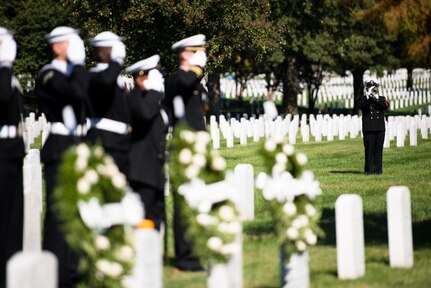 A bugler plays Taps in Arlington National Cemetery, Arlington, Va., Oct. 12, 2015, during a ceremony to remember the 17 American Sailors killed during the terrorist attack against the USS Cole.