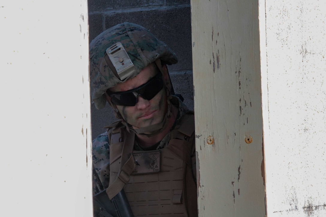 U.S. Marine Corps Lance Cpl. Alexander Dawson, a mortarman with 1st Battalion 8th Marines, peeks out of a window to provide security during a raid training exercise at Camp Lejeune, N.C., Sept. 22, 2020. The purpose of the exercise was to promote familiarization with ship to shore procedures and raid tactics for pre-deployment readiness with the 24th Marine Expeditionary Unit. (U.S. Marine Corps photo by Lance Cpl. Davis Harris)