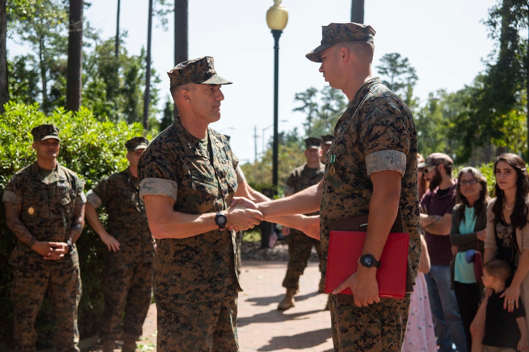 Major Gen. Francis Donovan, 2nd Marine Division commanding general, congratulates HM1 Michael D. Bryson on his achievements during an award ceremony at Camp Lejeune, N.C., September 22, 2020. Bryson received the Chief Hospital Corpsman George William “Doc” Piercy award, which recognizes one Navy corpsmen who has earned the Fleet Marine Force (FMF) badge for contributing to the combat readiness of any air or ground element in the Marine Corps. Bryson also received a Navy Commendation Medal for his outstanding service and accomplishments while serving as a corpsman for 1st Battalion 8th Marine Regiment. (U.S. Marine Corps photo by Lance Cpl. Nicholas Guevara)