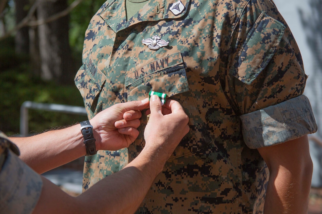 U.S. Navy Corpsman HM1 Michael D. Bryson, a corpsman with 1st Battalion 8th Marine Regiment, receives a Navy Commendation Medal during an award ceremony at Camp Lejeune, N.C., September 22, 2020. Bryson received the Chief Hospital Corpsman George William “Doc” Piercy award (not pictured), which recognizes one Navy corpsmen who has earned the Fleet Marine Force (FMF) badge for contributing to the combat readiness of any air or ground element in the Marine Corps. Bryson also received a Navy Commendation Medal for his outstanding service and accomplishments while serving as a corpsman for 1st Battalion 8th Marine Regiment. (U.S. Marine Corps photo by Lance Cpl. Nicholas Guevara)