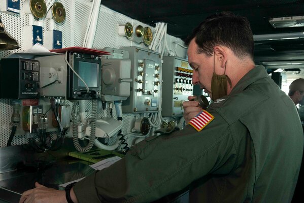 Capt. Max Clark, commanding officer of the aircraft carrier USS Nimitz (CVN 68), addresses the crew from the bridge on the 20th anniversary of the attack on USS Cole (DDG 67).