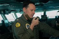 Capt. Max Clark, commanding officer of the aircraft carrier USS Nimitz (CVN 68), addresses the crew from the bridge on the 20th anniversary of the attack on USS Cole (DDG 67).