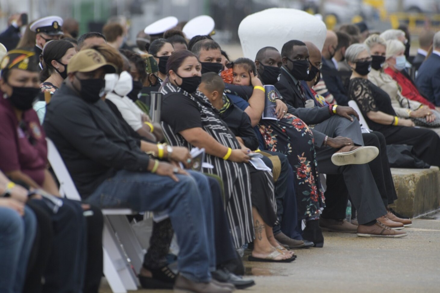 Gold Star Families and guests watch a memorial video during the Arleigh Burke-class guided missile destroyer USS Cole (DDG 67) 20th Anniversary memorial ceremony at Naval Station Norfolk.