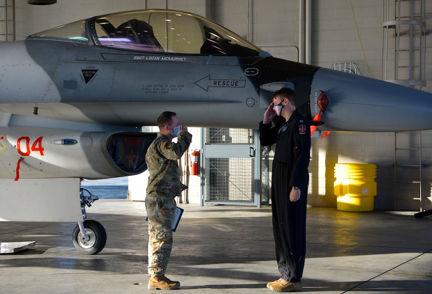 U.S. Air Force Staff Sgt. Logan McMurrey, a 354th Aircraft Maintenance Squadron F-16 Fighting Falcon dedicated crew chief (DCC), salutes Capt. Daniel Thompson, an 18th Aggressor Squadron F-16 pilot, on Eielson Air Force Base, Alaska, Oct. 9, 2020. A DCC is responsible for all maintenance of their aircraft and ensuring it is ready and safe for a pilot to fly. (U.S. Air Force photo by Senior Airman Beaux Hebert)