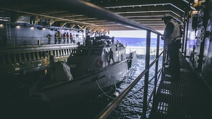 U.S. Sailor assigned to amphibious dock landing ship USS Comstock (LSD 45), observes a Patrol Boat (PB) Mk VI assigned to Maritime Expeditionary Security Squadron 3 during green well operations, Oct. 4, 2020. Maritime Expeditionary Security Force and Explosive Ordnance Disposal Mobile Unit Sailors assigned to Commander, Task Force 75 (CTF 75) embarked and are conducting integrated littoral maritime security operations from the amphibious dock landing ship USS Comstock (LSD 45) with the Marines and Sailors already deployed as Task Force Ellis from I Marine Expeditionary Force. PB Mk VI provides increased capabilities to amphibious warships and can operate directly in support of the Navy platform or independently in support of mission tasking. (U.S. Marine Corps photo by Sgt. Manuel A. Serrano)