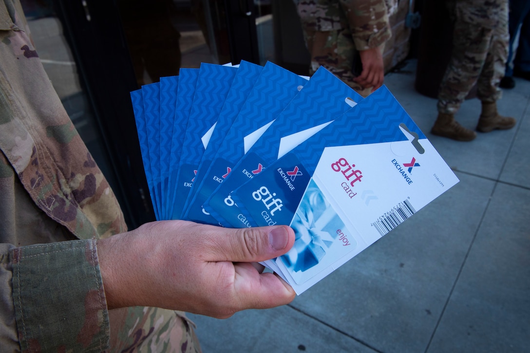A photo of a sergeant holding gift cards.
