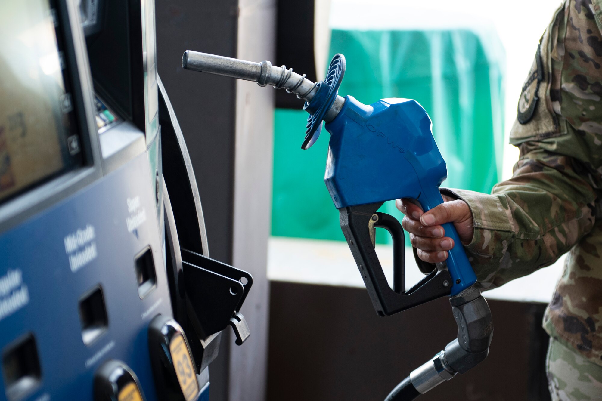 A photo of an Airman grabbing a gas pump.
