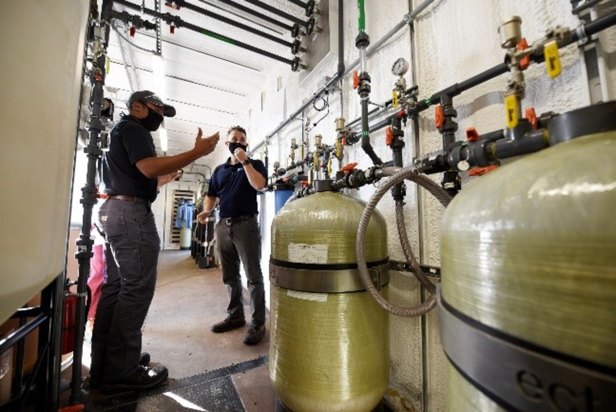 Brad Geisman, left, pilot engineer, and Dan Casey, lead field operations engineer for Emerging Compounds Treatment Technologies (ECT2), discuss the patented regenerable ion exchange (SORBIX RePURE) water  treatment system being used to remove per- and polyfluoroalkyl substances (PFAS) from groundwater at the fire training area of Wright-Patterson Air Force Base, Ohio on Sept. 29, 2020.  U.S. Air Force personnel from the Air Force Civil Engineer Center are leading the study of combining proven remediation techniques that can remove PFAS with new destruction technologies to  destroy the PFAS. PFAS are a group of chemicals, some of which were formerly used in aircraft fire fighting foam. (U.S. Air Force photo by Ty Greenlees)