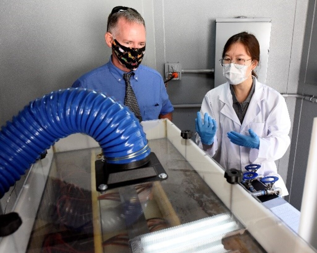 Dr. Shangtao Liang, right, electrochemical oxidation subject matter expert and principal investigator, AECOM, describes the DE-FLUOROTM process to George Walters, supervisory environmental engineer, Air Force Civil Engineer Center, at Wright-Patterson Air Force Base, Ohio on Sept. 29, 2020. DE-FLUOROTM electrochemical oxidation is the final step to remediate per- and polyfluoroalkyl substances (PFAS) from groundwater near the base fire training area.  This project is the first field demonstration using the electrochemical oxidation technology for PFAS destruction. PFAS is a group of chemicals, some of which were formerly used in aircraft fire fighting foam. (U.S. Air Force photo by Ty Greenlees)
