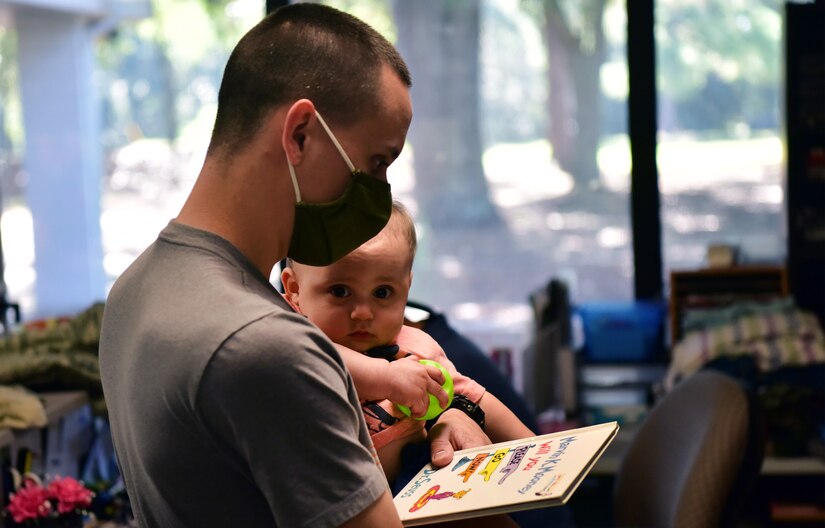 U.S. Air Force Airman 1st Class Kevin Sangregory, an aircrew flight equipment technician from the 437th Operations Support Squadron, looks through a selection of children’s toys with his nine month old son, Weston Cole, at the Airman’s Attic located at Joint Base Charleston, S.C., Oct. 7, 2020. Courtney Blackwell, lead volunteer at Joint Base Charleston’s Airman’s Attic, works with a team of volunteers to provide service members an opportunity to obtain uniform items, clothing items, non-perishable foods, and kitchen utensils free of charge.