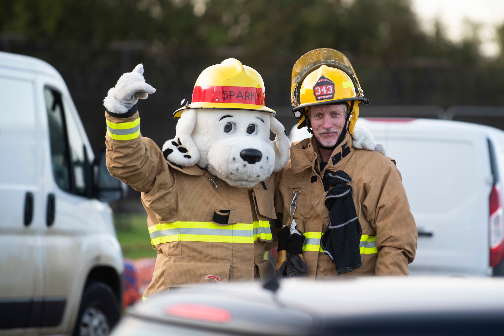 Sparky the Fire Dog and Bob Ratcliffe, 423rd Civil Engineer Squadron firefighter, pose for a photo at RAF Molesworth, England, Oct. 6, 2020 during Fire Prevention Week 2020. Since 1922, national Fire Prevention Week is intended to educate the public about the importance of pre-planning actions they should take to keep themselves and their families safe from fire mishap. (U.S. Air Force photo by Senior Airman Jennifer Zima)