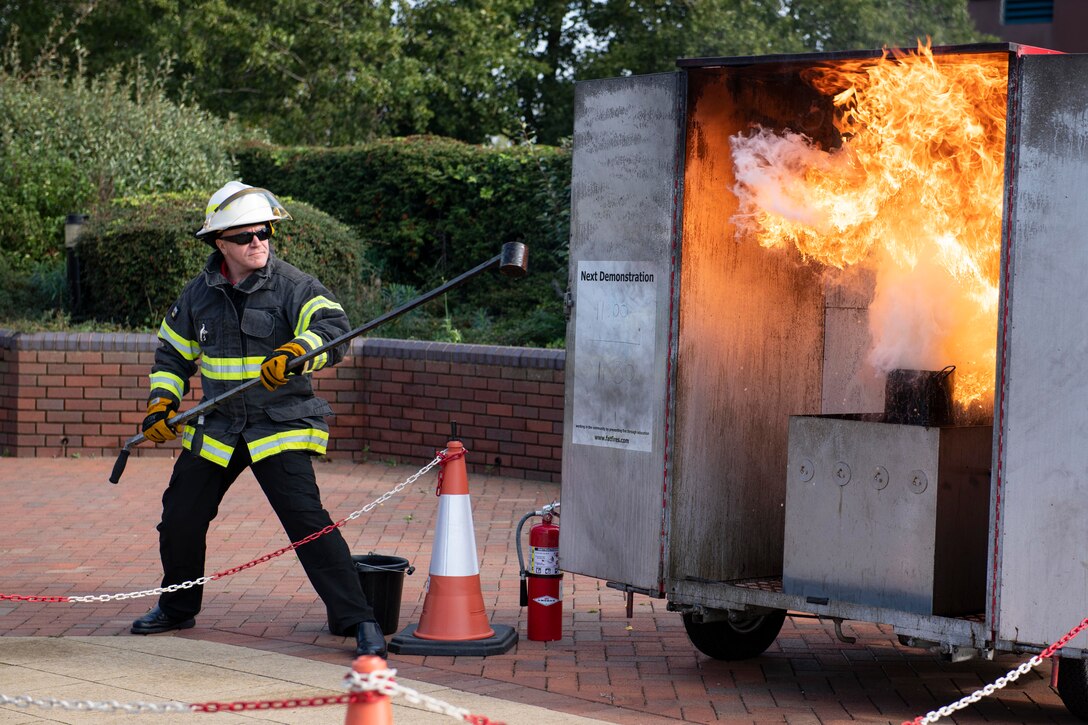 Dave Herman, 423rd Civil Engineer Squadron assistant chief of fire prevention, talks about kitchen fire safety with a grease fire demonstration at RAF Molesworth, England, Oct. 6, 2020 during Fire Prevention Week 2020. Herman showed that placing a lid on a fire is safer than pouring water, especially on a grease fire, which can ignite into large flames. (U.S. Air Force photo by Senior Airman Jennifer Zima)