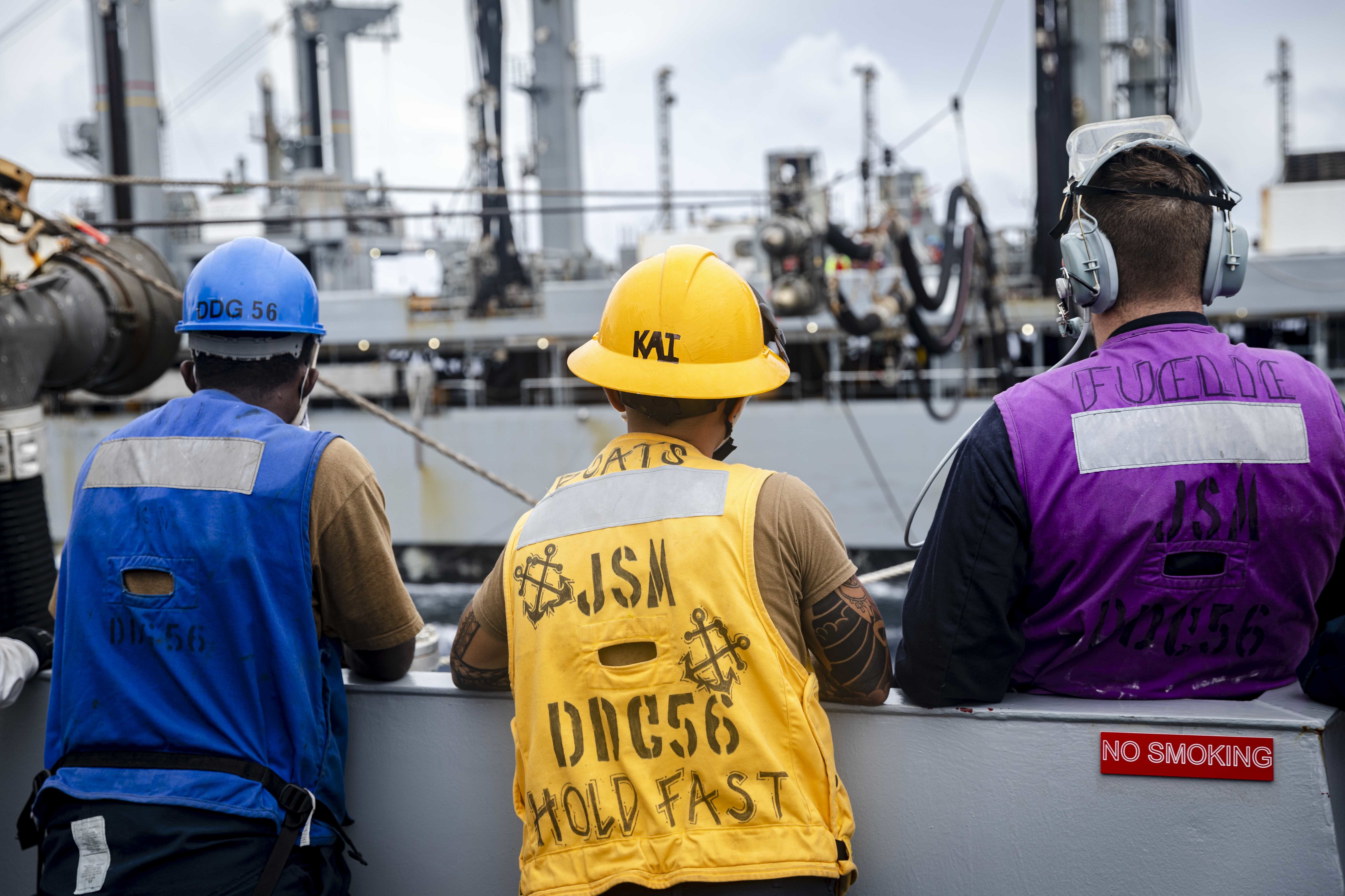 Sailors aboard the Arleigh Burke-class guided-missile destroyer USS John S. McCain (DDG 56) man a refueling station as the ship conducts a replenishment-at-sea with the fleet replenishment oiler USNS Tippecanoe (T-AO 199).