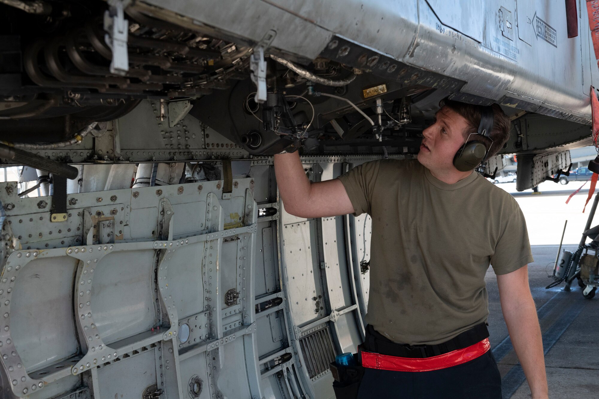 A photo of an Airman installing a GAU-8 Avenger 30 mm cannon ammunition element on an A-10C Thunderbolt II.
