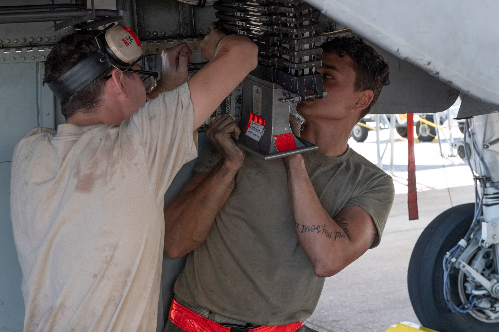 A photo of Airmen installing a GAU-8 Avenger conveyor element on an A-10C Thunderbolt II.
