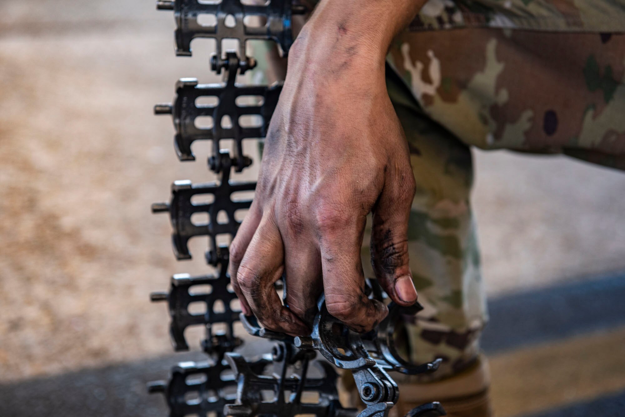 A photo of an Airman holding conveyor elements for the GAU-8 Avenger 30 mm cannon.