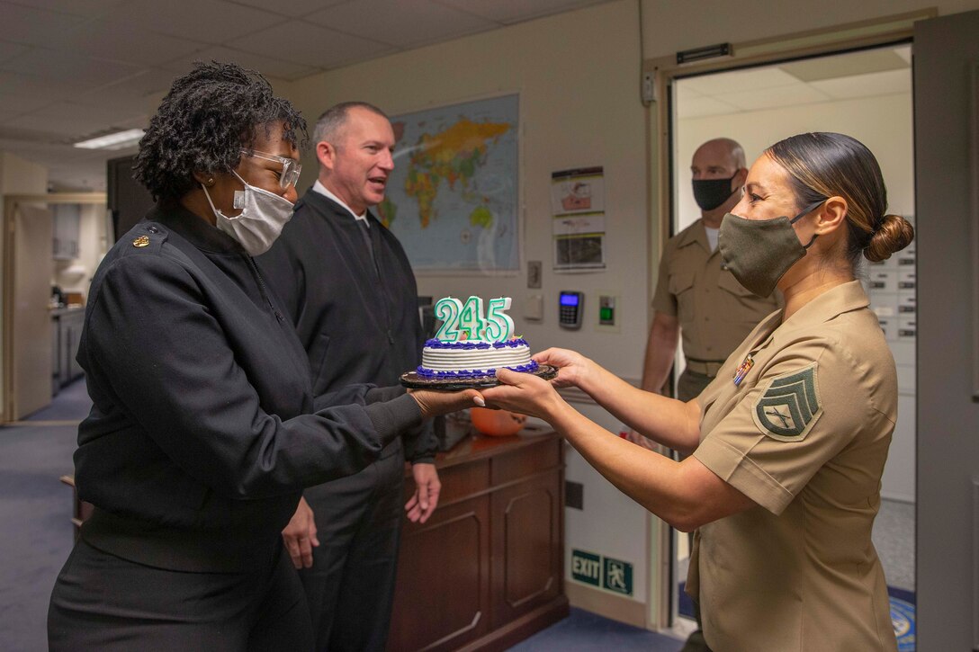 The 19th Sergeant Major of the Marine Corps, Sgt. Maj. Troy E. Black and his staff deliver a birthday cake to the Master Chief Petty Officer of the Navy Russell Smith office, Washington DC, Oct. 13, 2020. The cake was delivered to celebrate the Navy’s 245th birthday. The Navy and Marine Corps team continues to define the future character of maritime concepts and remains a ready to respond to an increasingly complex and dangerous world. (U.S. Marine Corps photo by Sgt. Victoria Ross)