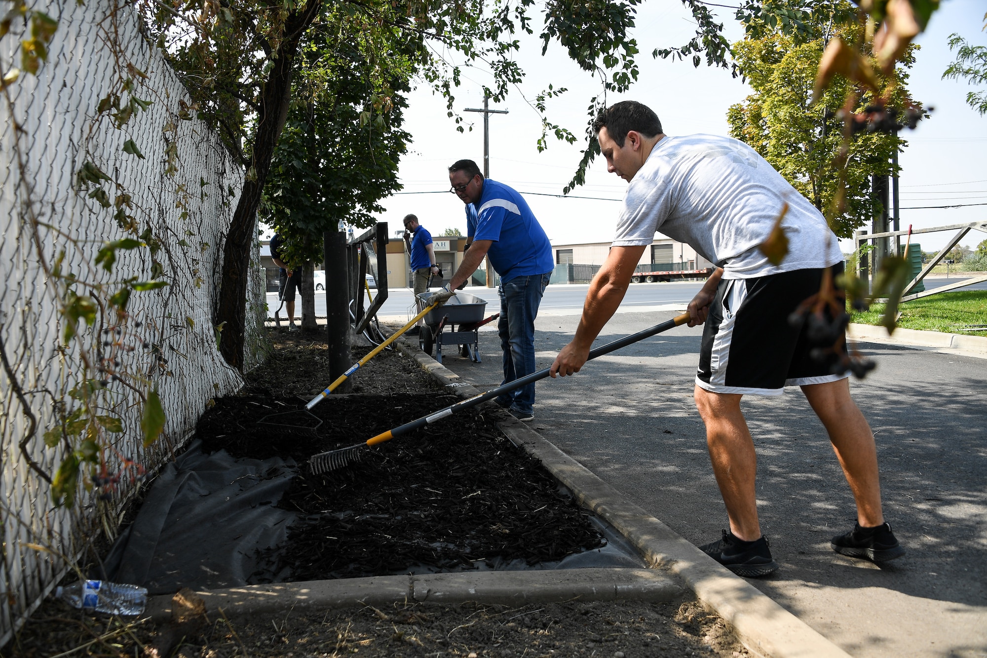 Jeff Gorton and Brandon Bailey (front, left to right), volunteers from the Air Force Nuclear Weapons Center’s Ground Based Strategic Deterrent Systems directorate at Hill AFB, Utah, put down new bark in a parking strip at the Safe Harbor Crisis Center in Kaysville, Utah, on Sept. 17, 2020. The crisis center provides shelter and support services to survivors of domestic abuse and sexual assault. (Air Force photo by R. Nial Bradshaw)