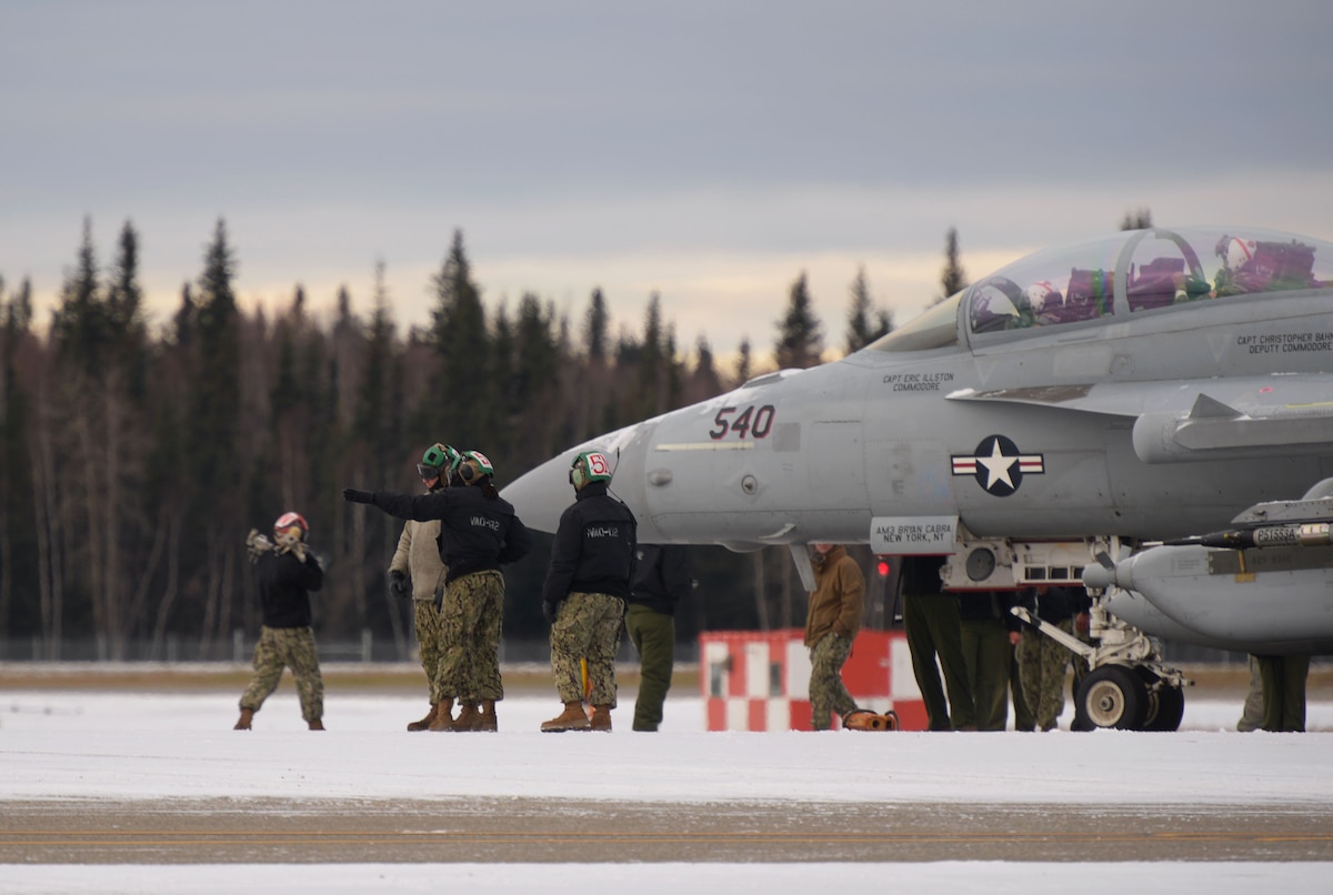 U.S. Navy aircraft mechanics assigned to the Electronic Attack Squadron (VAQ) 132 perform maintenance on an EA-18G Growler during RED FLAG-Alaska 21-1 on Eielson Air Force Base, Alaska, Oct. 13, 2020. RED FLAG-Alaska exercises are designed to provide training for deployed aircrew, maintenance and support personnel in sustainment of large-force deployed air operations. (U.S. Air Force photo by Senior Airman Beaux Hebert)