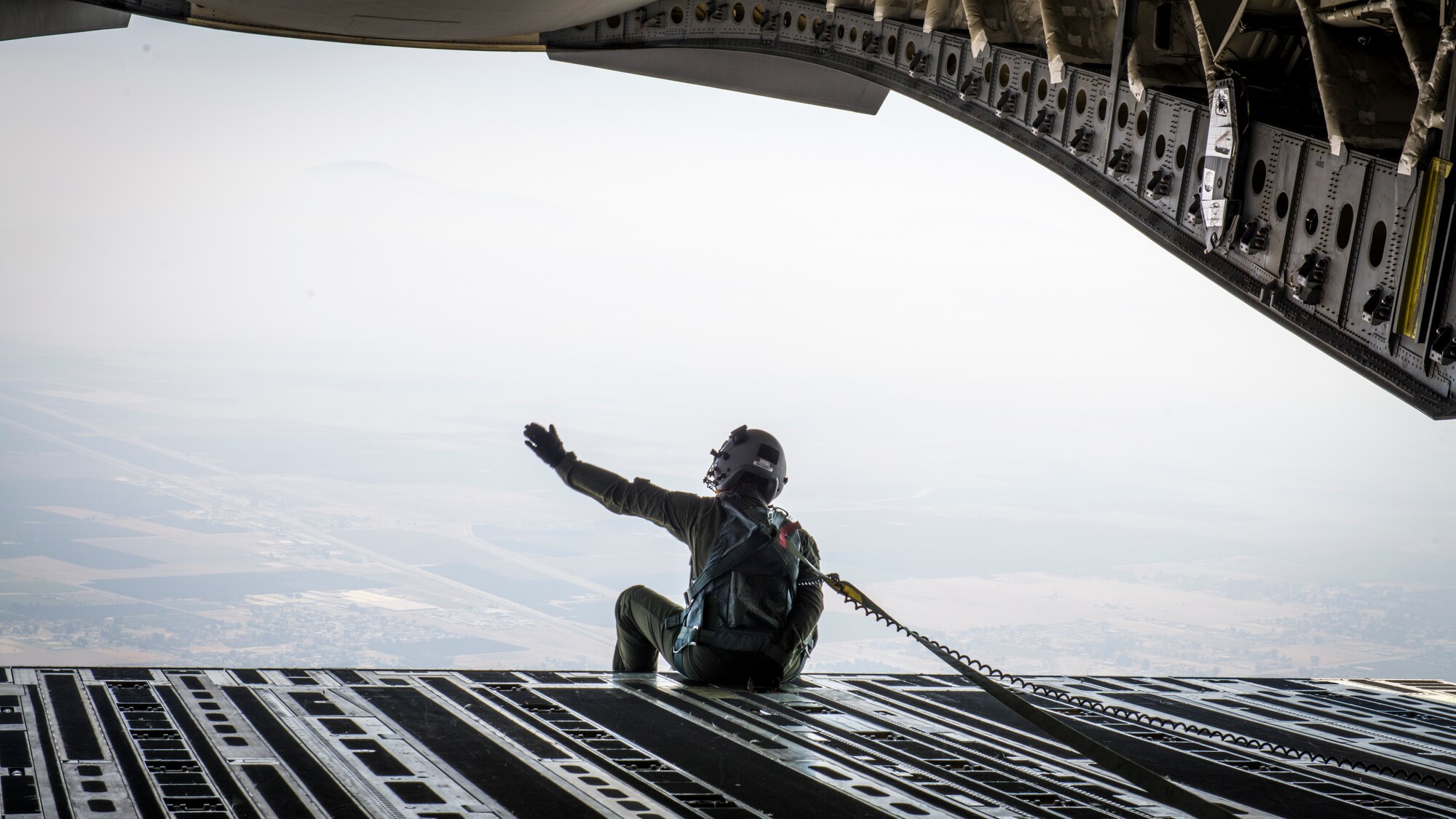 Staff Sgt. Kori Myers, 418th Flight Test Squadron C-17 load master, waves from the back of a C-17 Globemaster III during the 2020 Aerospace Valley Air Show at Edwards Air Force Base, Oct. 9. (Air Force photo by Giancarlo Casem)