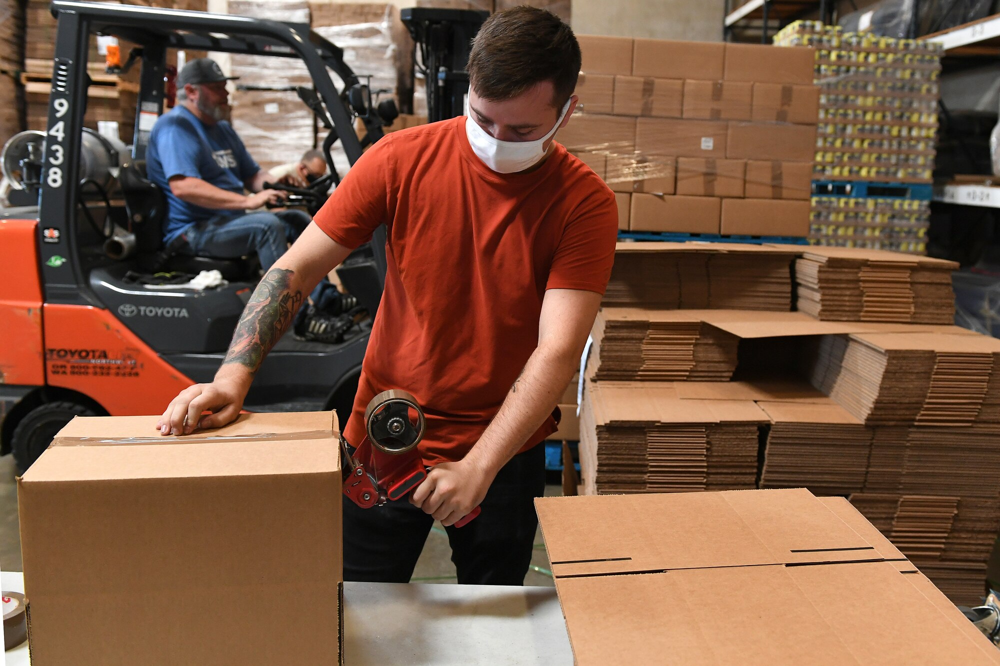 Eric Cunningham, 194th Wing student flight, constructs boxes at a Lakewood, Washington food bank packing facility in Sept. 2, 2020. Cunningham and the team of Washington National Guardsmen at the Lakewood facility are able to make 2,000 boxes a day. The WA NG are supporting the food banks as part of the states Covid response efforts. (Air National Guard photo by Master Sgt. Chacon)