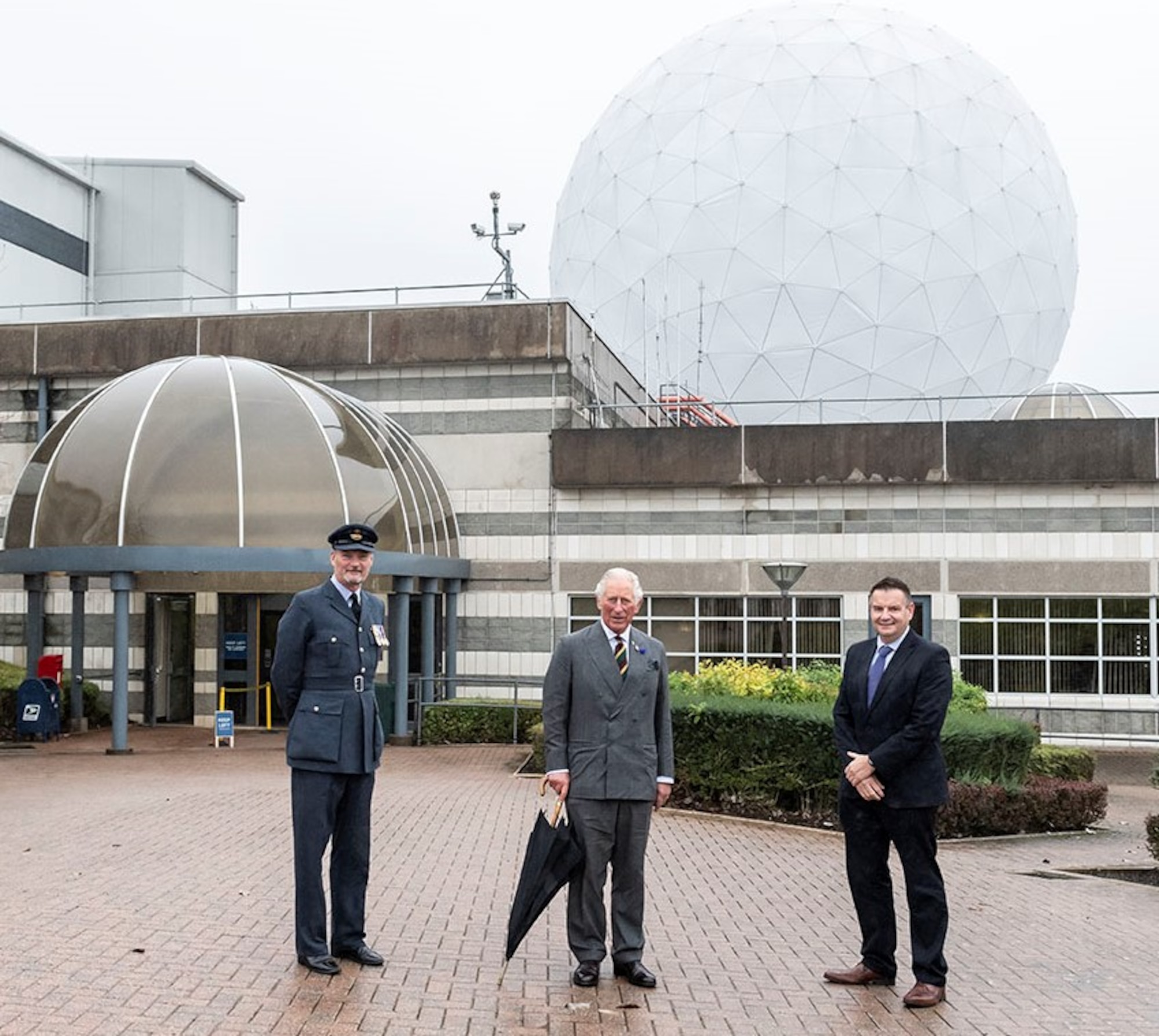 His Royal Highness, center, the Prince of Wales poses for a photo along with Squadron Leader Geoff Dickson, left, RAF Commander for RAF Menwith Hill and Mr Gav Smith, Director General of Technology, Government Communications Headquarters, at RAF Menwith Hill, England, Oct. 12, 2020. (Courtesy Photo)