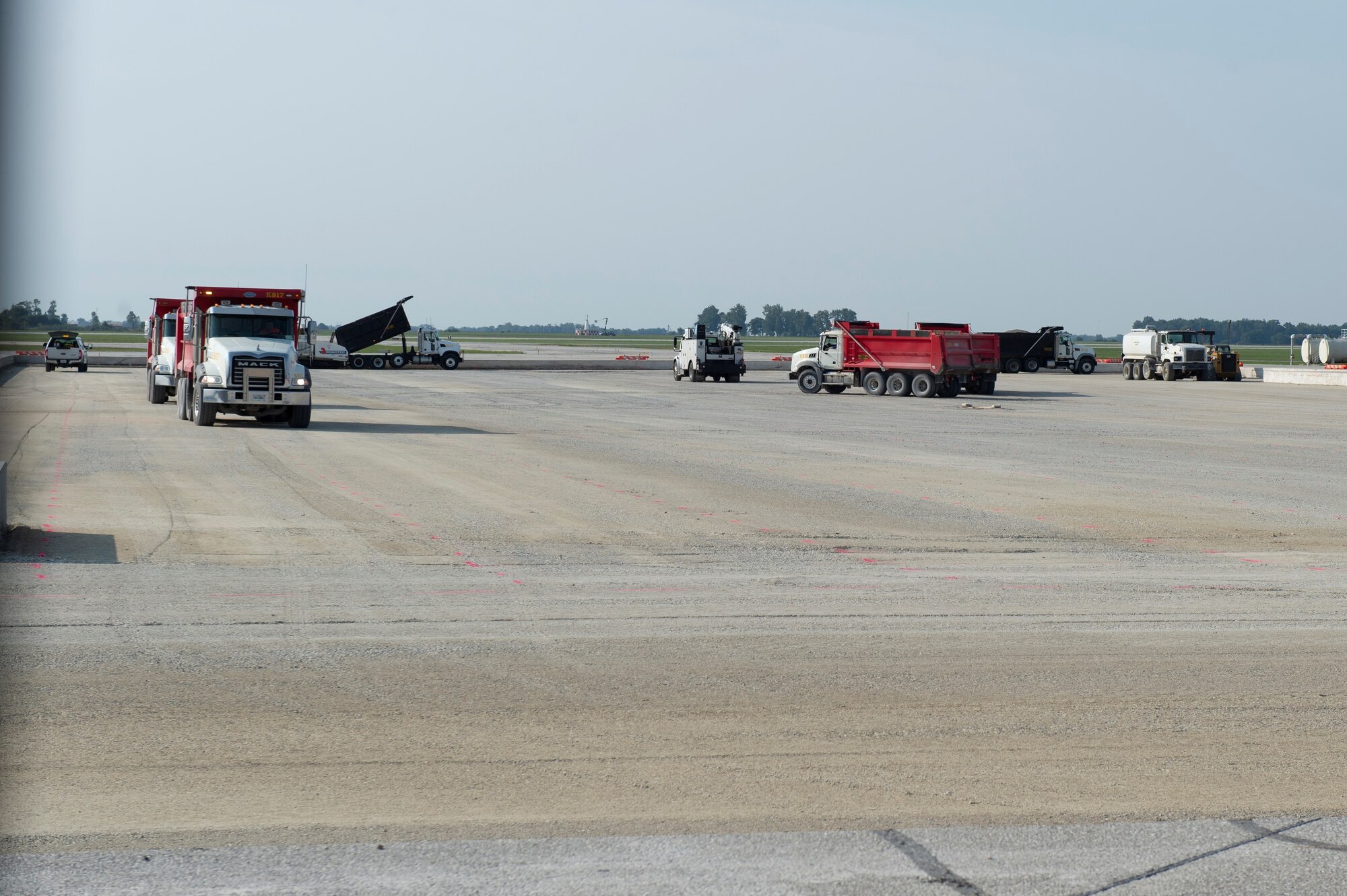 Dump trucks remove old concrete from the flightline at Grissom Air Reserve Base, Indiana, Sept. 23, 2020. The part of the flightline needed to be replaced as part of its routine structural maintenance. (U.S. Air Force photo by Staff Sgt. Michael Hunsaker)