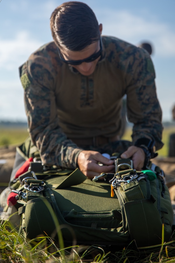 A Marine with 3rd Force Reconnaissance Company, 4th Marine Division checks his parachute during an airborne operations event at Camp Shelby, Miss., Oct. 6, 2020. Reservists with 3rd Force Recon train to remain the nation’s force in readiness, prepared to go, fight, and win at a moment's notice. (U.S. Marine Corps photo by Cpl. JVonnta Taylor)