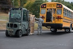 Members of the Connecticut Air National Guard, 103rd Logistics Readiness Squadron, load Farmers to Families Food Boxes onto a school bus at the Killingly Highway Department in Dayville, Connecticut, Sept. 30, 2020. The boxes were going to be delivered to homes and food pantries.
