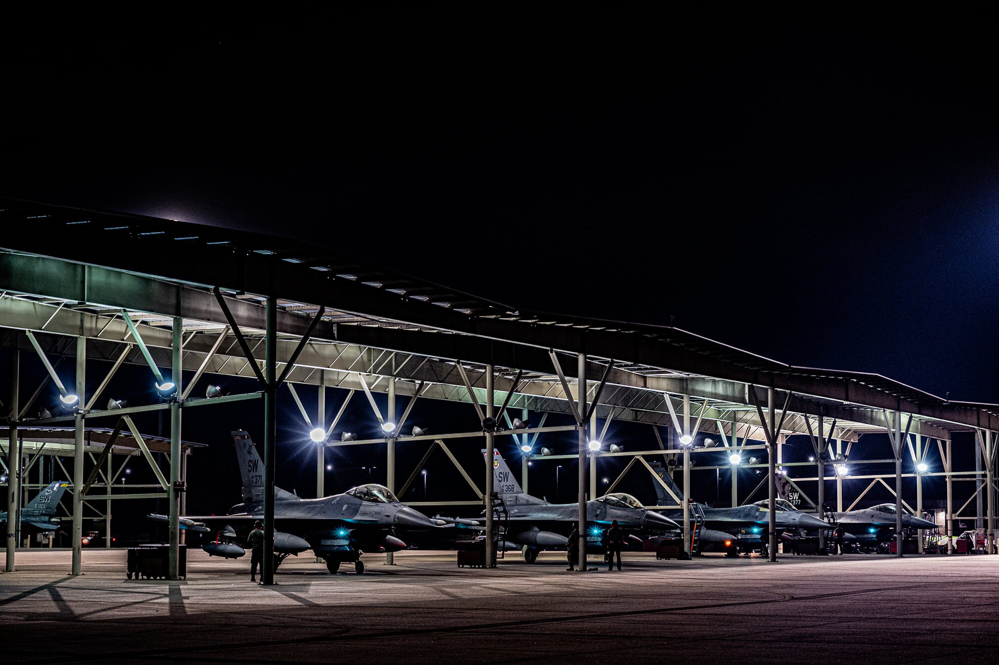 A line of F-16 Vipers await takeoff on the flightline.