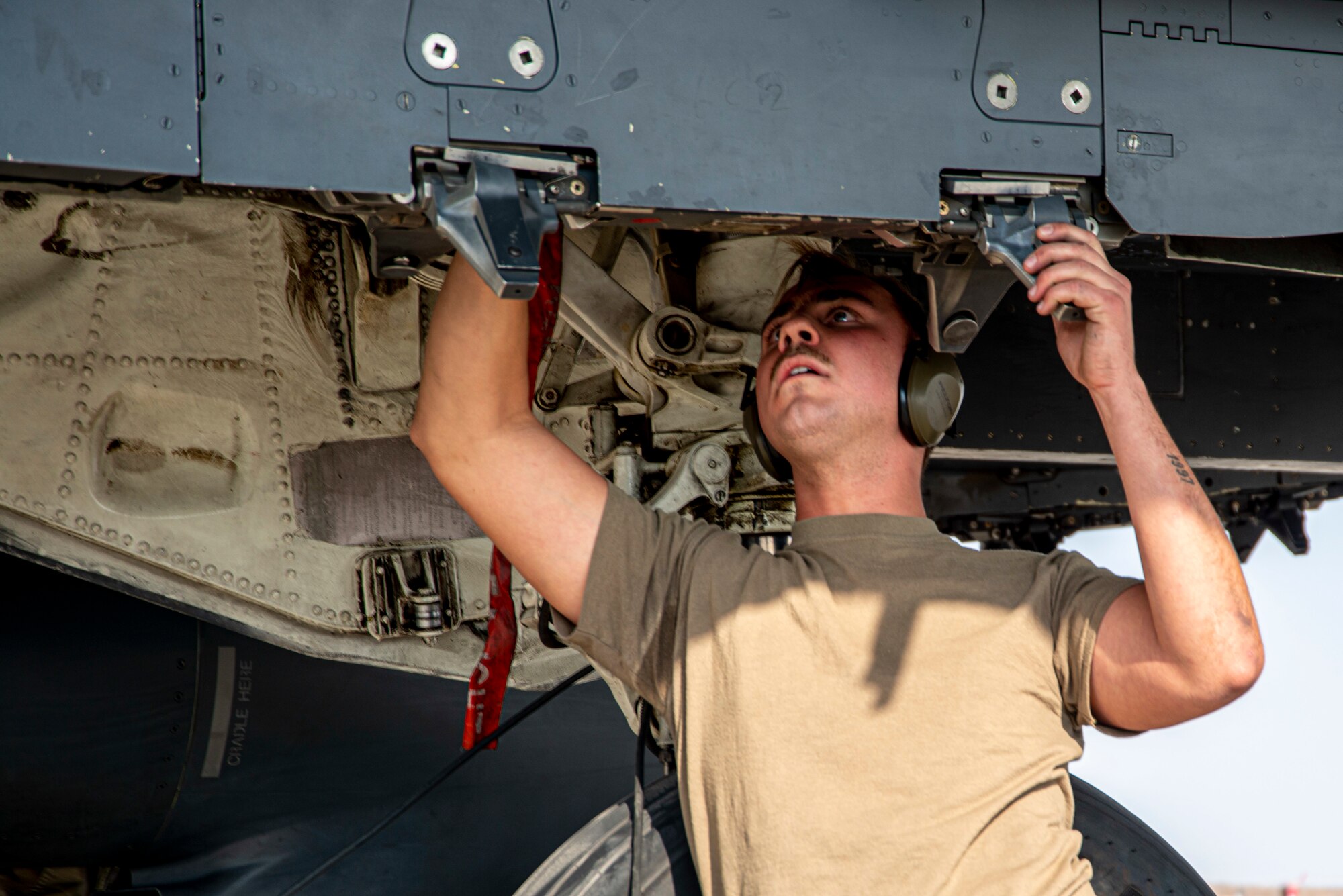 Senior Airman Nicholas Alford, 389th Fighter Squadron weapons load crew member, prepares a bomb rack for weapons loading during an Integrated Combat Turn exercise at Mountain Home Air Force Base, Idaho, Oct. 7, 2020. ICTs are a rapid re-arming and refueling practice where both fuels and weapons troops work side-by-side to turn aircraft around and get them back into the skies. (U.S. Air Force photo by Senior Airman JaNae Capuno)