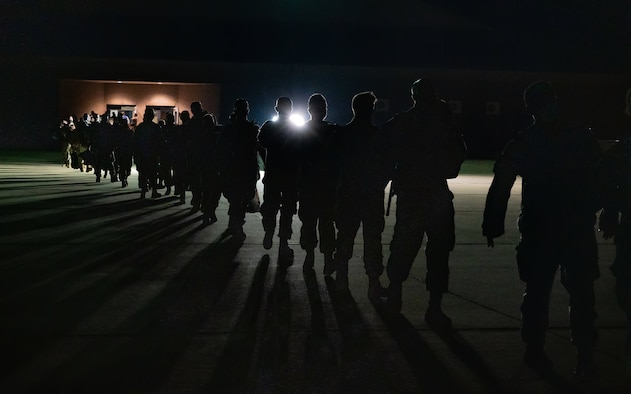 Airmen stand out on the flightline awaiting deployment.