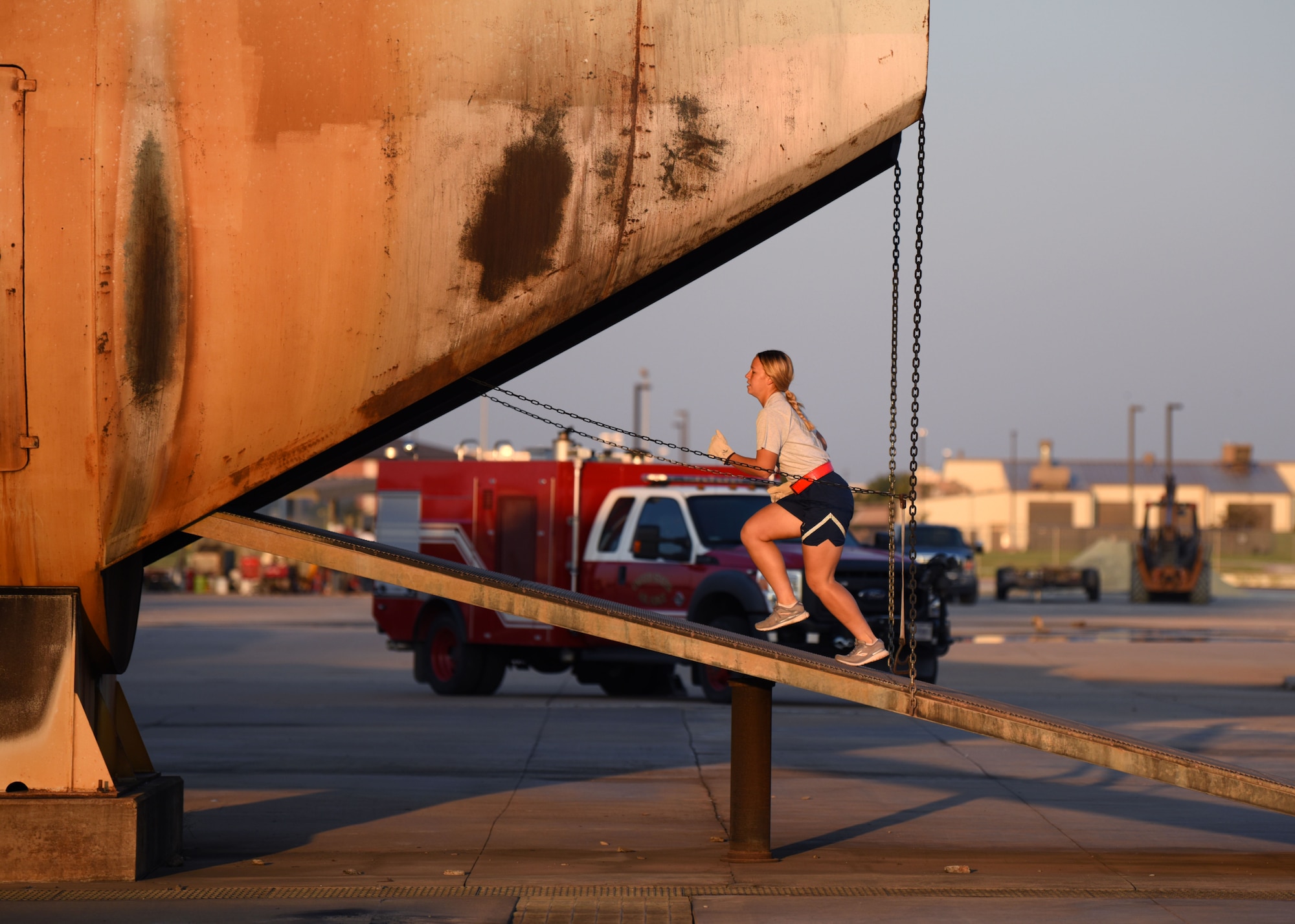 A 312th Training Squadron student enters an aircraft fire trainer during Blood, Sweat, and Stairs at the Louis F. Garland Department of Defense Fire Academy, on Goodfellow Air Force Base, Texas, Oct. 10, 2020. Each obstacle simulated the challenges first responders faced during the attacks on 9/11. (U.S. Air Force photo by Airman 1st Class Ethan Sherwood)