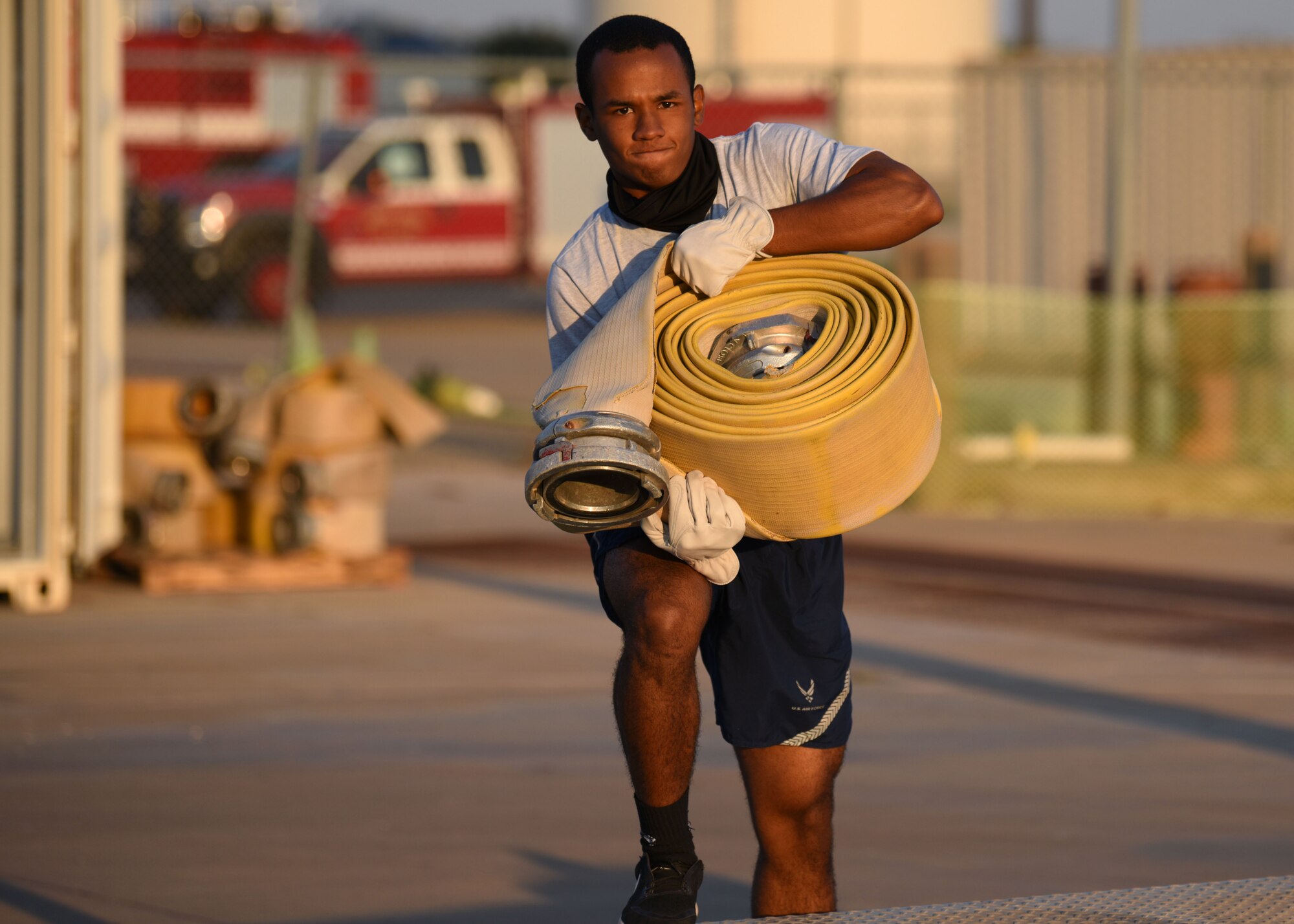 A 312th Training Squadron Student steps onto a platform with a five-inch-hose during Blood, Sweat, and Stairs at the Louis F. Garland Department of Defense Fire Academy, on Goodfellow Air Force Base, Texas, Oct. 10, 2020. This event represented first responders who had to carry heavy equipment into the twin towers to extract survivors during 9/11. (U.S. Air Force photo by Airman 1st Class Ethan Sherwood)
