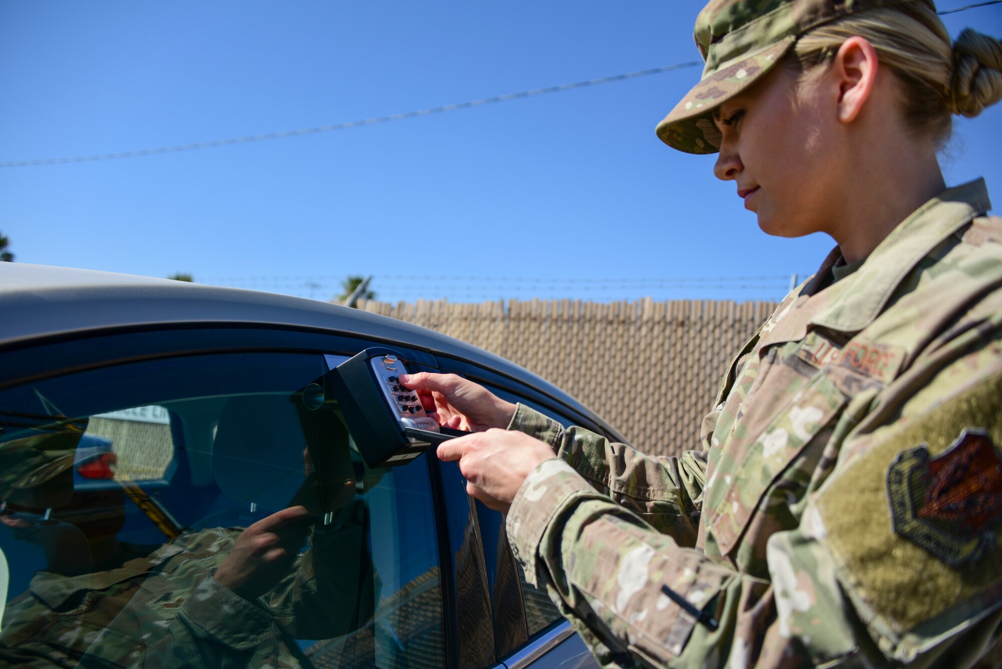 Airman entering PIN code into a lock box.