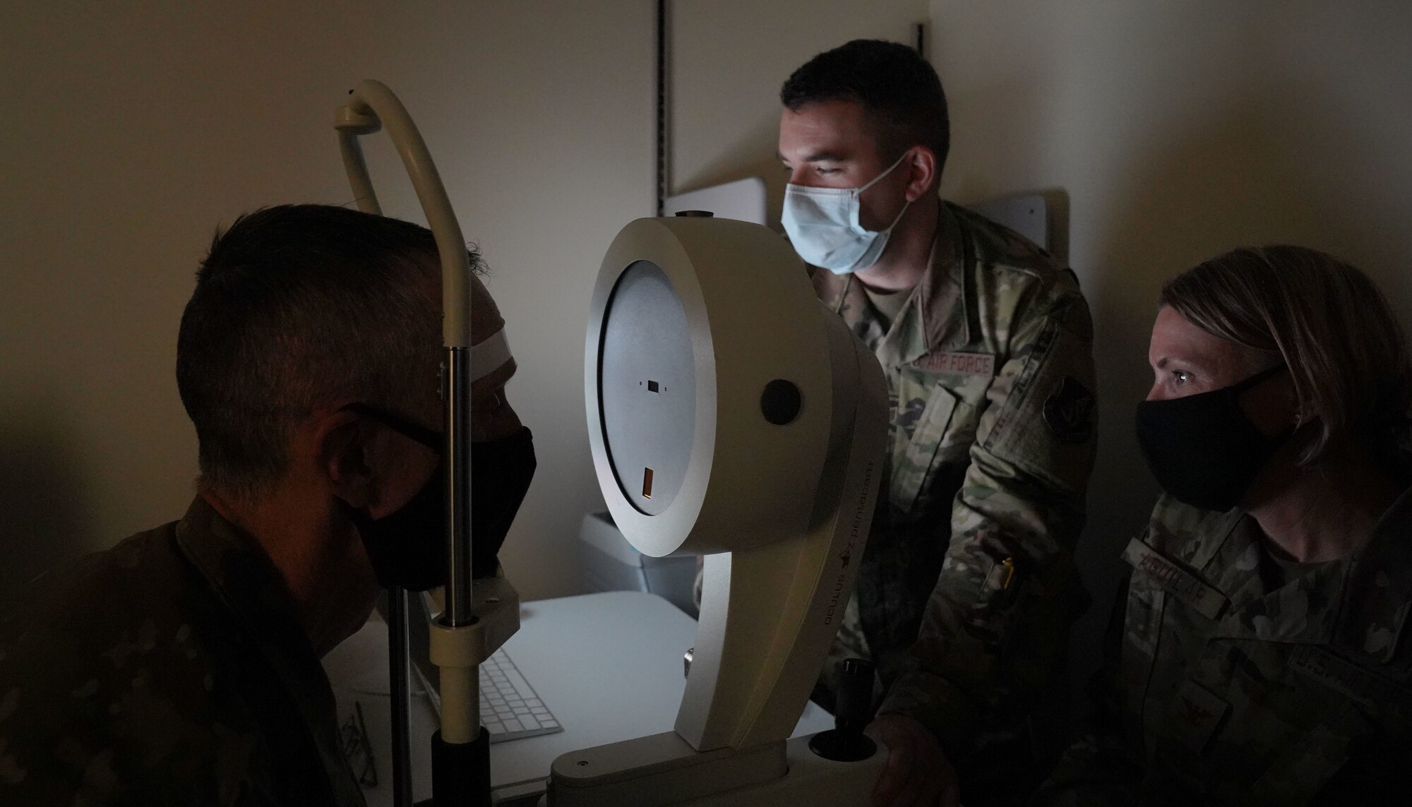 U.S. Air Force Staff Sgt. Simon Arnold, 673d Surgical Operations Squadron ophthalmology technician, demonstrates a retinal exam on U.S. Air Force Chief Master Sgt. Lee Mills, Joint Base Elmendorf-Richardson and 673d Air Base Wing command chief, for U.S. Air Force Col. Kirsten Aguilar, JBER and 673d ABW commander, during a 673d SGCS immersion tour at Joint Base Elmendorf-Richardson, Alaska, Sept. 29, 2020. Aguilar familiarized herself with the 673d SGCS and its role in supporting readiness after taking command of the installation July 14, 2020. The 673d SGCS provides a full range of medical care to include surgical and non-surgical intervention to JBER and the greater Anchorage area.