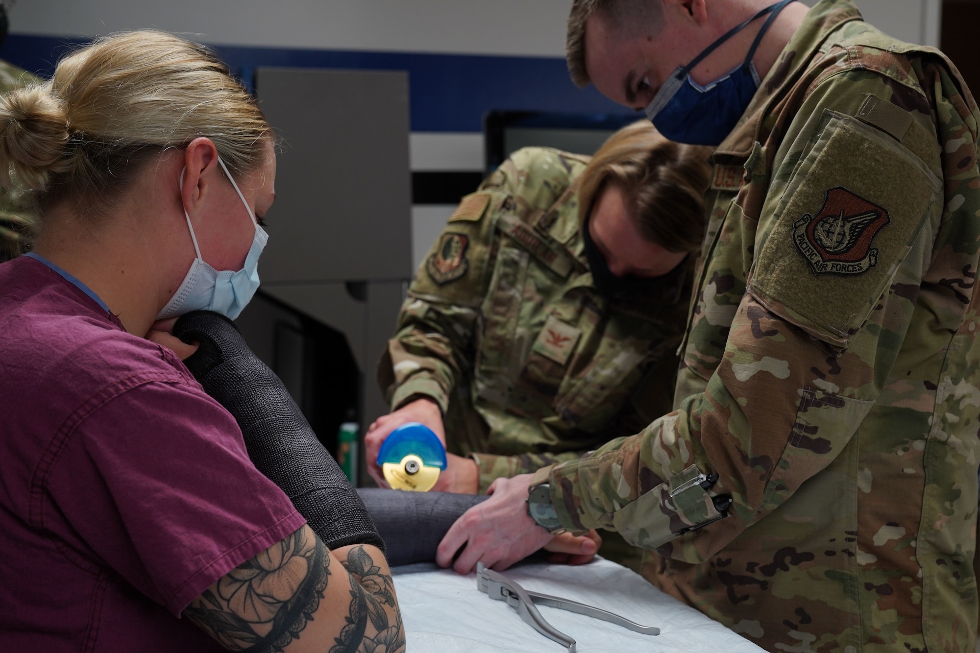 U.S. Air Force Col. Kirsten Aguilar, Joint Base Elmendorf-Richardson and 673d Air Base Wing commander, uses a cast saw with assistance from U.S. Air Force Senior Airman Ian Fanning, 673d Surgical Operations Squadron orthopedic surgical technician, to remove a cast from U.S. Staff Sgt. Keating Miranda, 673 SGCS orthopedic surgical technician, cast during a 673d SGCS immersion tour at Joint Base Elmendorf-Richardson, Alaska, Sept. 29, 2020. Aguilar familiarized herself with the 673d SGCS and its role in supporting readiness after taking command of the installation July 14, 2020. The 673d SGCS provides a full range of medical care to include surgical and non-surgical intervention to JBER and the greater Anchorage area.